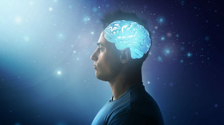 Handsome man with glowing brain on dark background